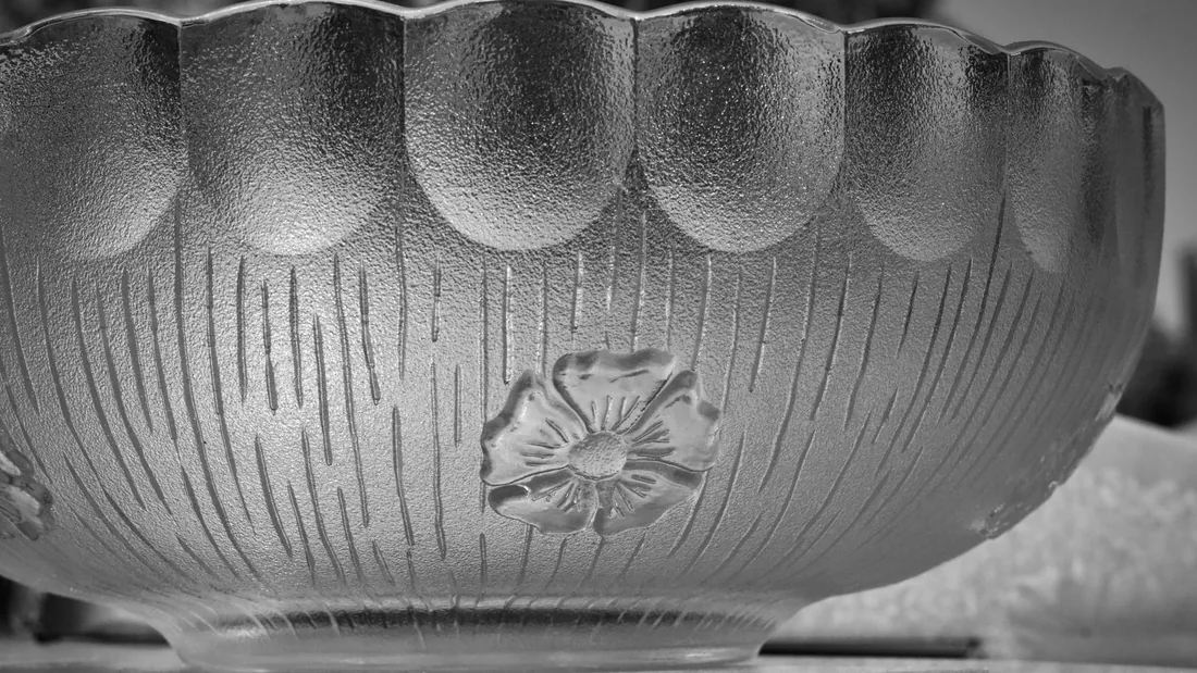 Cuenco de vidrio con la pared mate y un motivo floral en relieve, con líneas verticales grabadas alrededor
